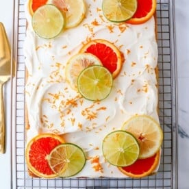 Citrus Sheet Cake made with with fresh squeezed orange, lemon, and lime juicies in a moist, fluffy cake and topped with a creamy and silky homemade cream cheese frosting and topped with citrus slices. A beautiful Spring and Summer celebration cake!