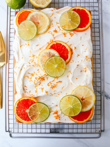 Citrus Sheet Cake made with with fresh squeezed orange, lemon, and lime juicies in a moist, fluffy cake and topped with a creamy and silky homemade cream cheese frosting and topped with citrus slices. A beautiful Spring and Summer celebration cake! 