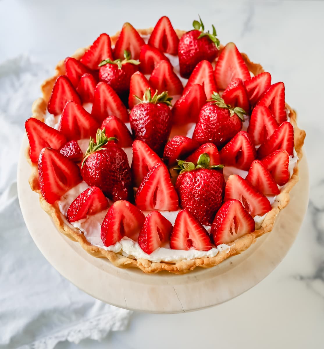 This Strawberry Cream Cheese Tart is made with a buttery tart crust, sweet vanilla cream cheese filling, and fresh strawberries with a shiny glaze. The perfect easy Summer strawberry dessert.