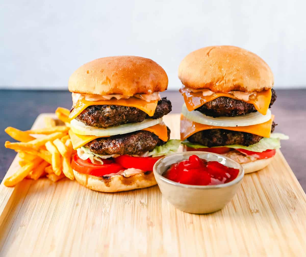 Classic All-American Cheeseburger with Cheddar Cheese and topped with burger sauce, lettuce, tomatoes, and onion. How to make the best homemade grilled cheeseburger...just like the In-N-Out Double-Double!