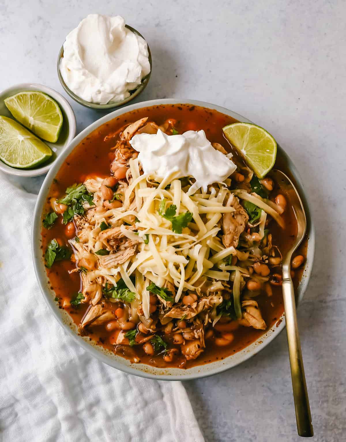 This Ranch Chicken Chili is a quick and easy soup recipe made with shredded chicken, onion, garlic, chili powder, green chilies, white beans, ranch powder, and topped with cheese and sour cream.