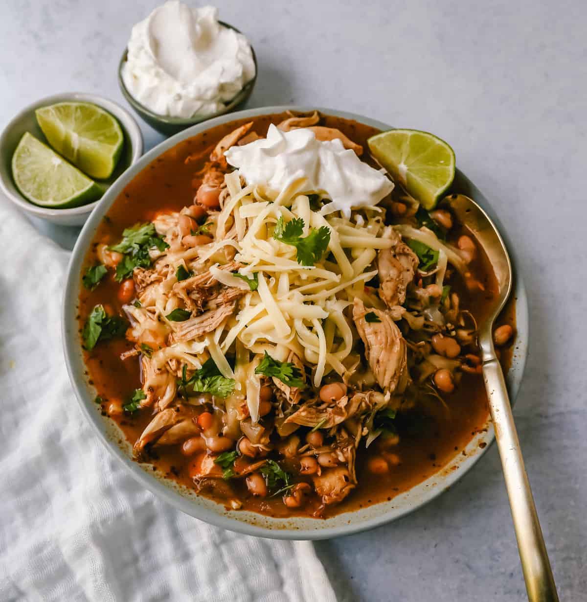 This quick and easy chicken chili is made in less than 30 minutes and filled with protein, good fats, and healthy carbs! This White Chicken Chili is a quick and easy soup recipe made with shredded chicken, onion, garlic, chili powder, green chilies, white beans, and ranch powder, and topped with cheese and sour cream.