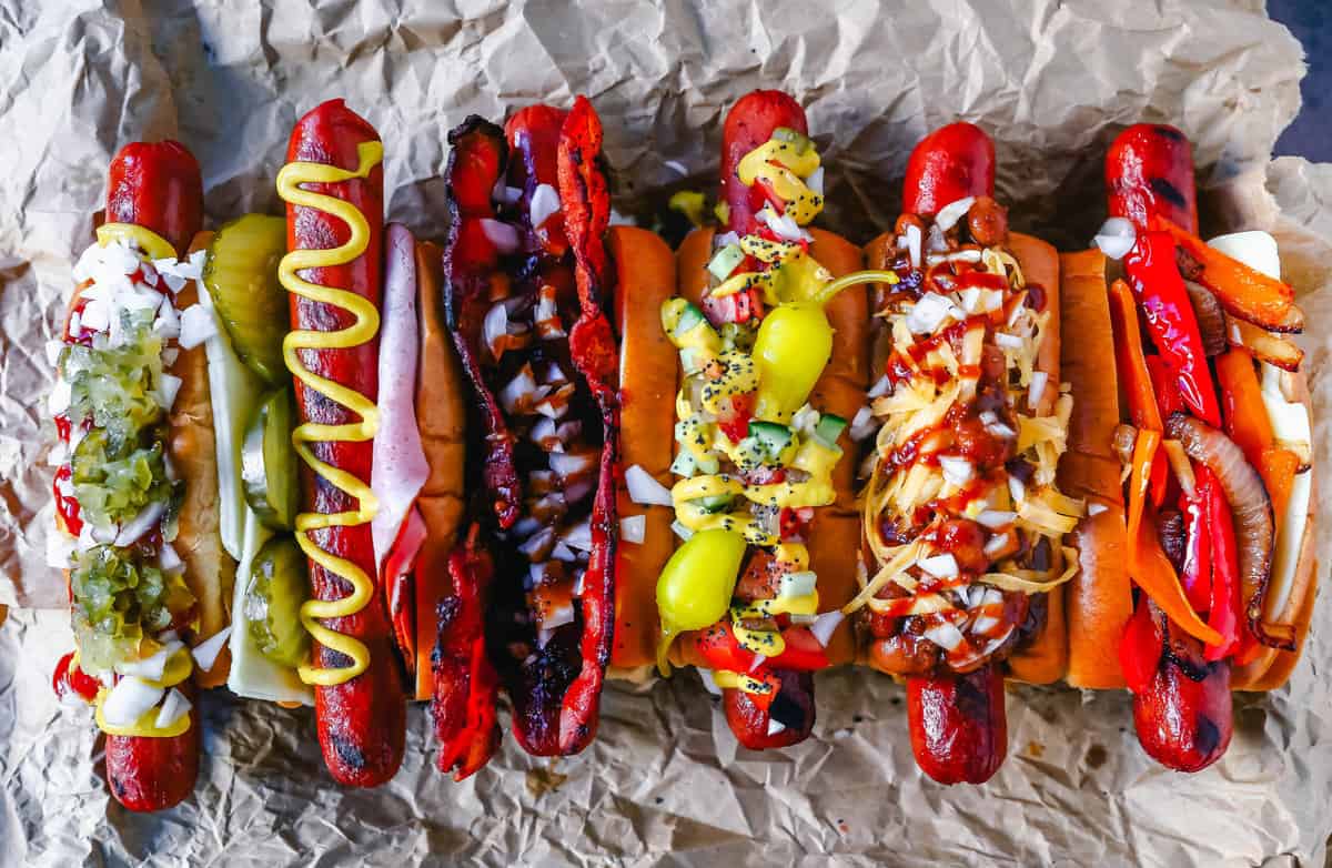 Πώς να δημιουργήσετε το απόλυτο Gourmet Hot Dogs με όλα τα νόστιμα toppings για hot dog.  Μπορείτε να δημιουργήσετε διάσημα χοτ ντογκ όπως τα Σικάγο Dogs, τα Chili Dogs, ακόμα και τα BBQ Bacon Dogs.  Συμβουλές για το πώς να μετατρέψετε ένα συνηθισμένο χοτ ντογκ στο πιο γευστικό χοτ ντογκ που θα φάτε ποτέ!