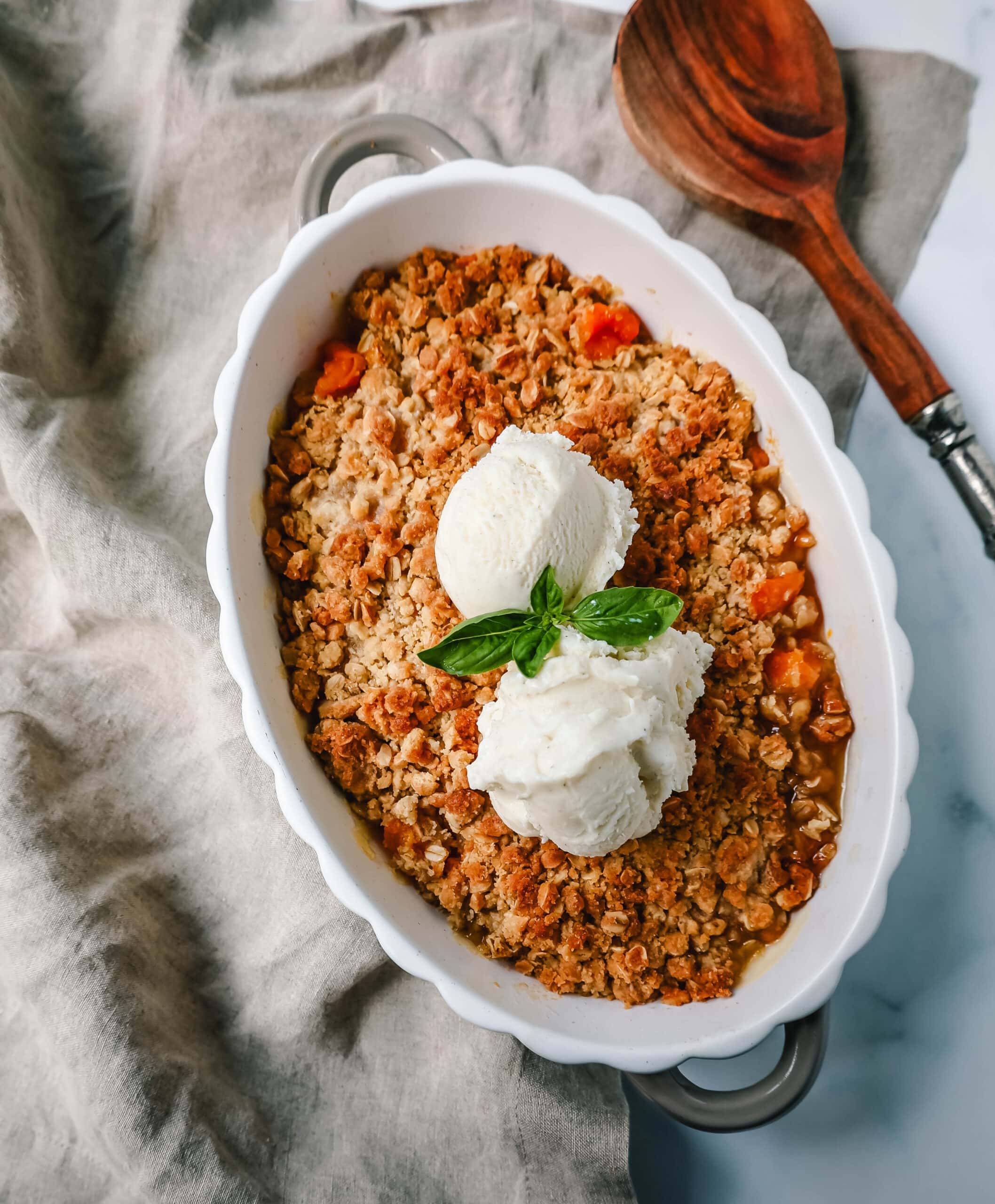 This Apricot Crisp is made with fresh apricots tossed in sugar and almond extract and topped with a homemade brown sugar oat crumble. This rustic summer dessert is served with a big scoop of vanilla bean ice cream. 