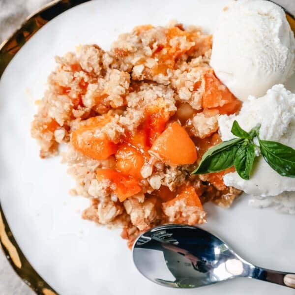 This Apricot Crisp is made with fresh apricots tossed in sugar and almond extract and topped with a homemade brown sugar oat crumble. This rustic summer dessert is served with a big scoop of vanilla bean ice cream. 