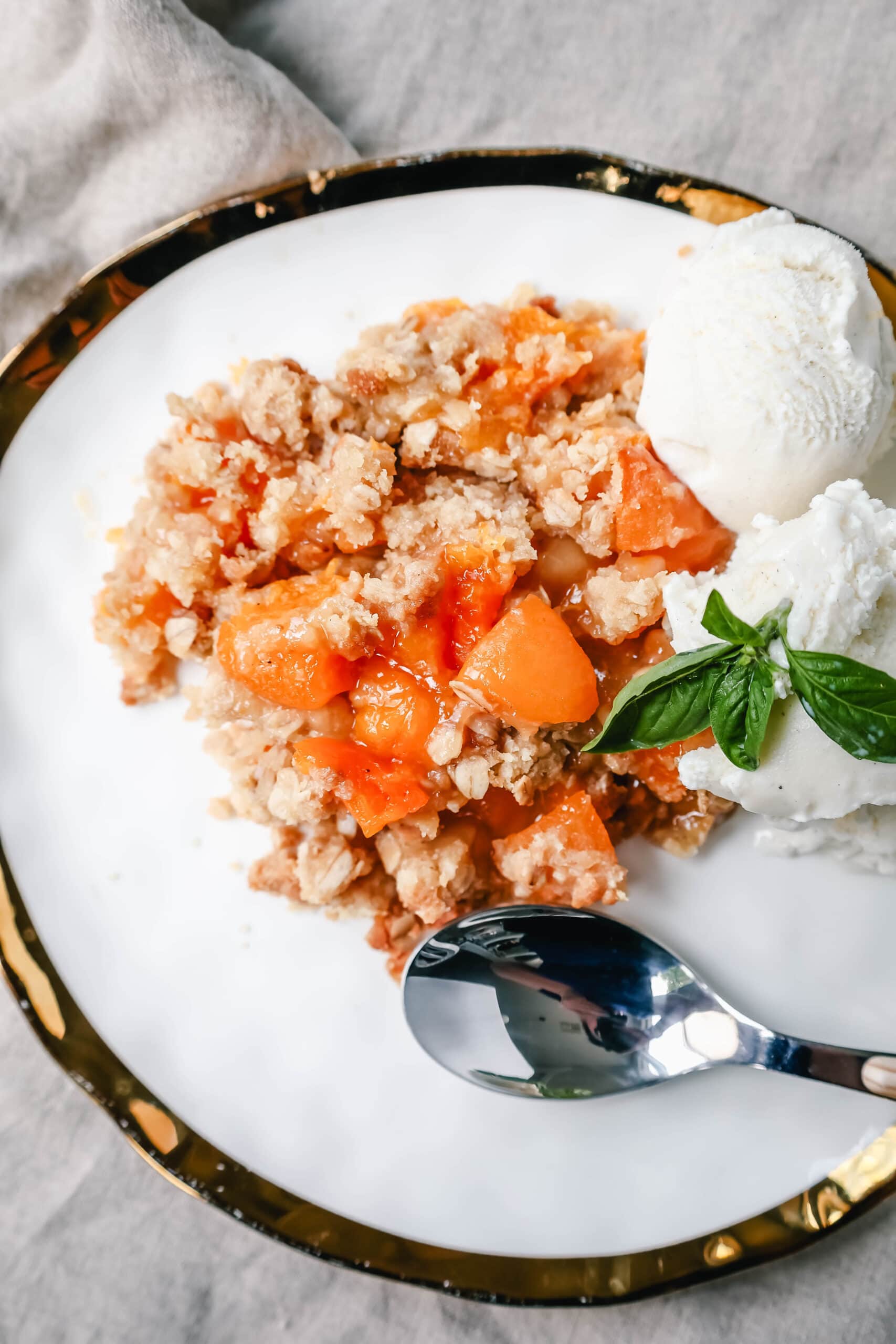 This Apricot Crisp is made with fresh apricots tossed in sugar and almond extract and topped with a homemade brown sugar oat crumble. This rustic summer dessert is served with a big scoop of vanilla bean ice cream. 