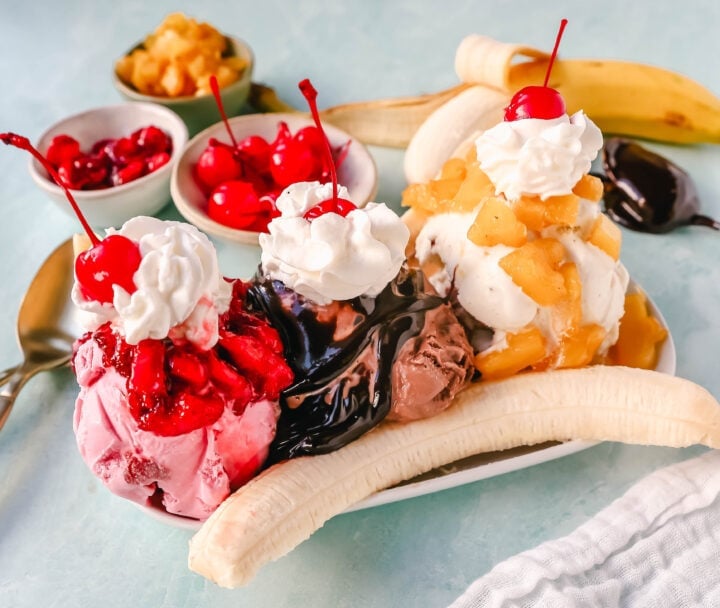 A classic Banana Split recipe made with fresh bananas, chocolate ice cream with hot fudge sauce, strawberry ice cream with strawberry sauce, vanilla ice cream with pineapple sauce, whipped cream, and cherry. 