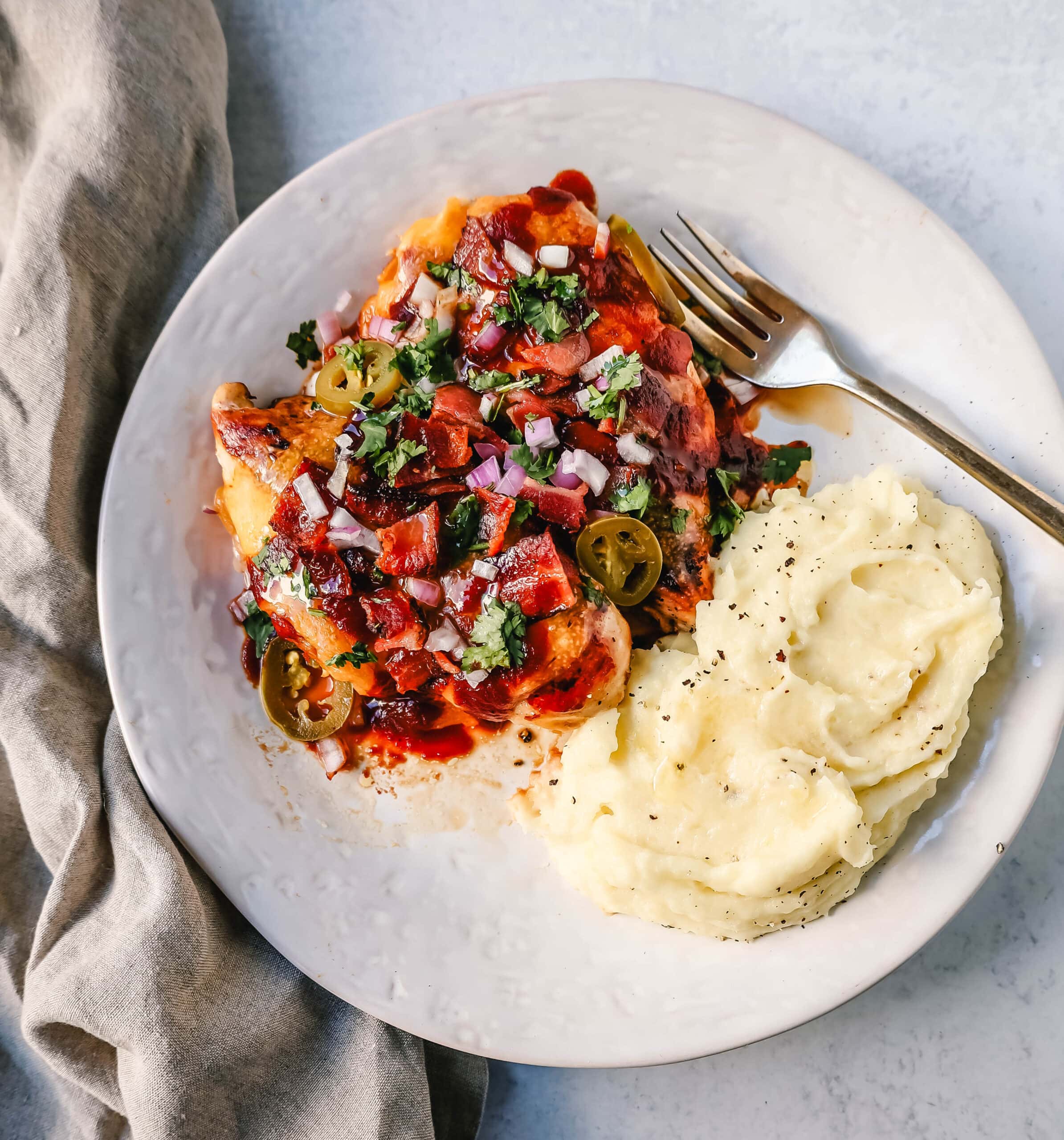 This Cowboy Chicken is Marinated Grilled Chicken topped with BBQ Sauce, Crispy Bacon, and Cheddar Cheese. Top with Fresh Cilantro and Red Onion. This is the best Monterey Chicken recipe!