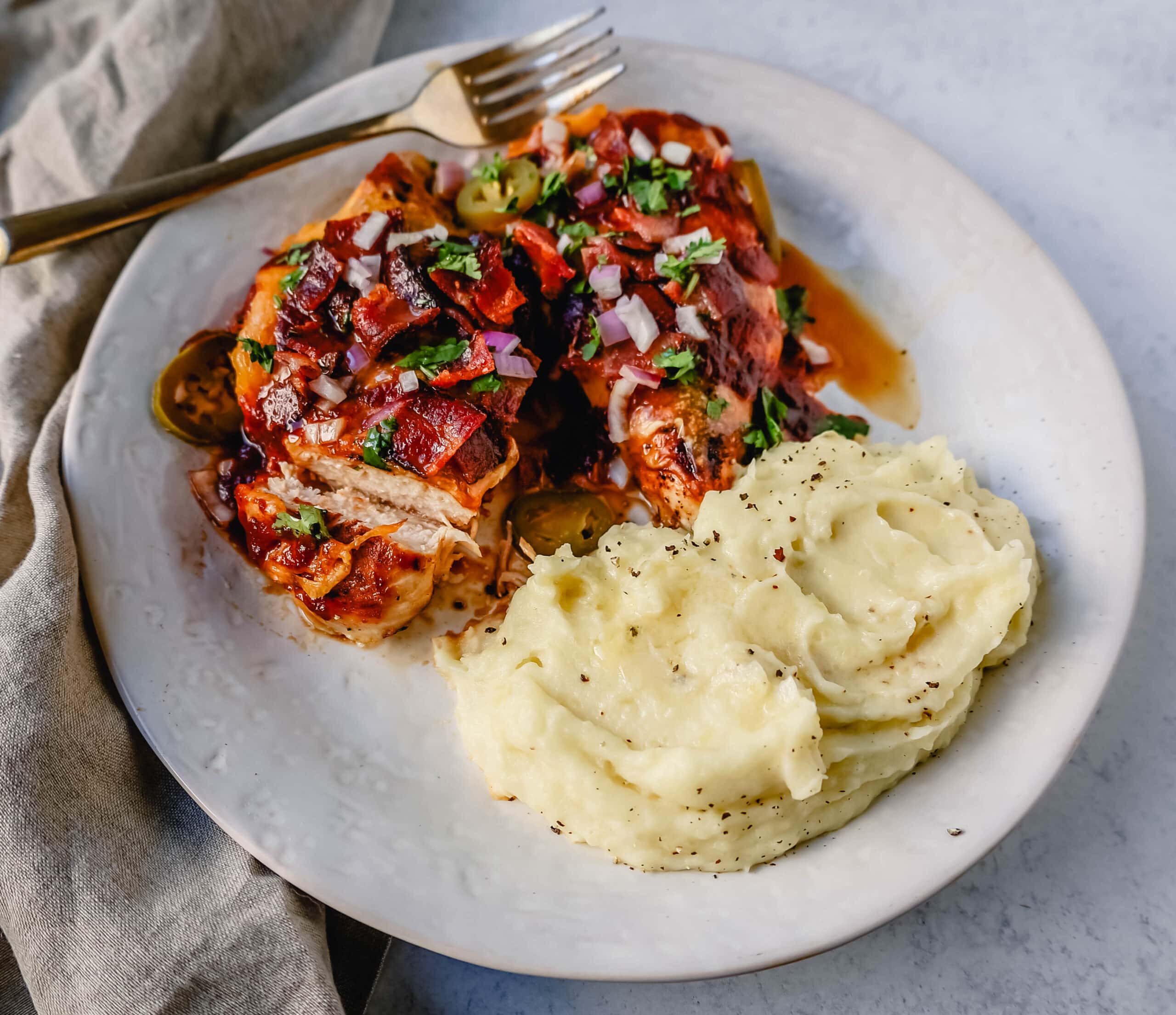 This Cowboy Chicken is Marinated Grilled Chicken topped with BBQ Sauce, Crispy Bacon, and Cheddar Cheese. Top with Fresh Cilantro and Red Onion. This is the best Monterey Chicken recipe!