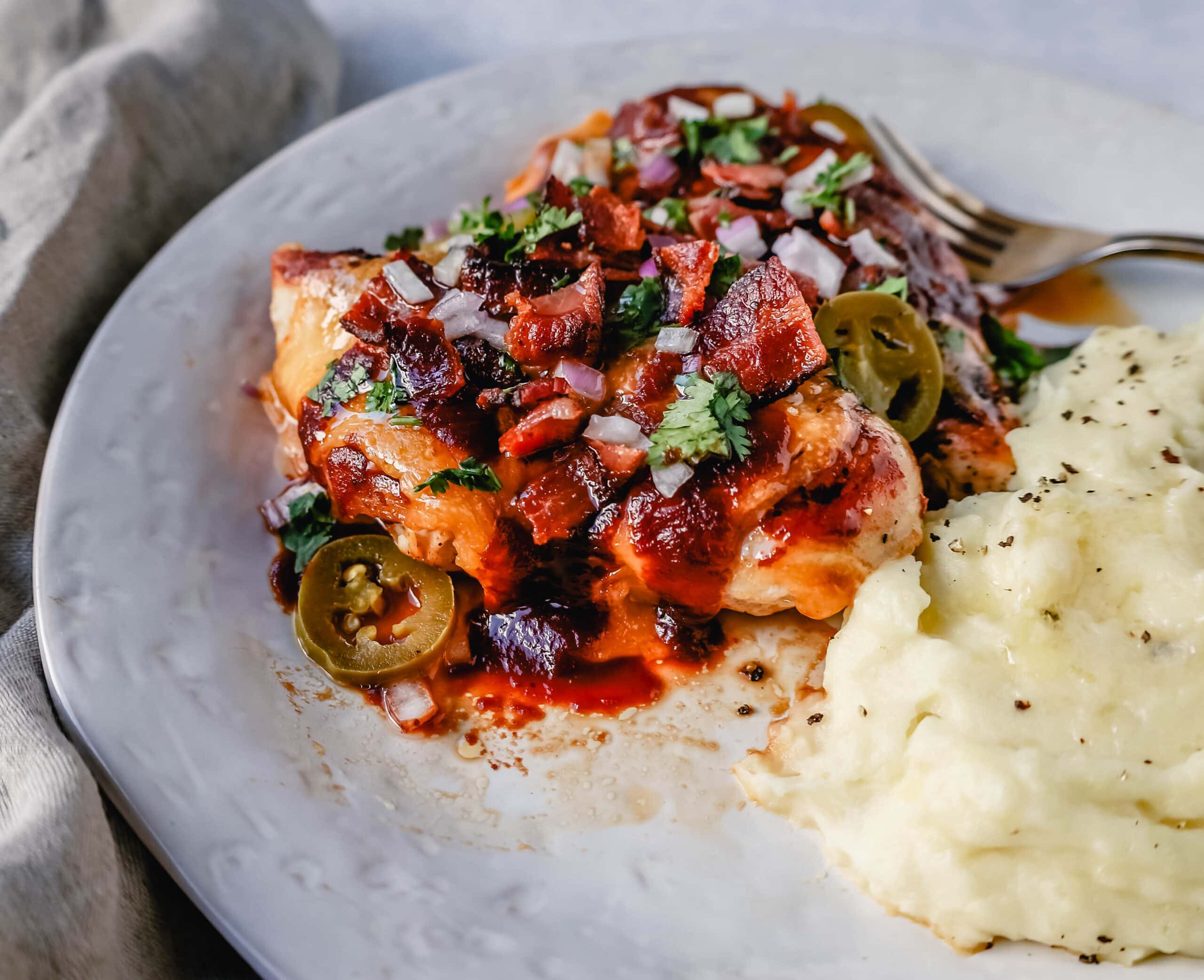 This Cowboy Chicken is Marinated Grilled Chicken topped with BBQ Sauce, Crispy Bacon, and Cheddar Cheese. Top with Fresh Cilantro and Red Onion. This is the best Monterey Chicken recipe!