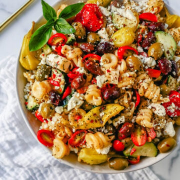 Homemade Greek Pasta Salad made with Pasta, Greek Olives, Feta Cheese, Peppers, Tomatoes, Cucumber, Pepperoncinis, and tossed in a Homemade Greek Dressing. The Best Greek Pasta Salad Recipe!