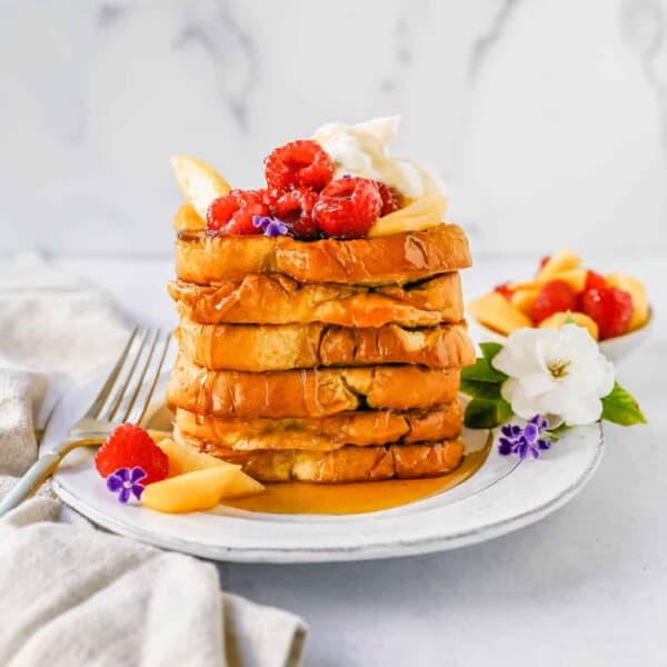 Easy Sheet Pan French Toast is made by dipping the bread into a custard batter and baking on a sheet pan in the oven. It makes it so much easier to make homemade french toast! Top this Oven Baked French Toast with a sweet Mascarpone Cream and Sweetened Fresh Fruit.