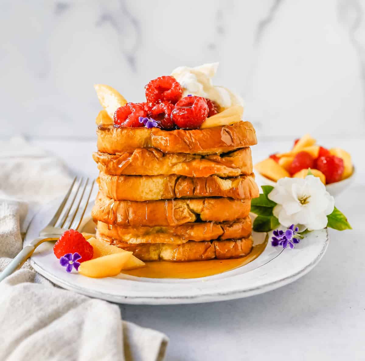 Easy Sheet Pan French Toast is made by dipping the bread into a custard batter and baking on a sheet pan in the oven. It makes it so much easier to make homemade french toast! Top this Oven Baked French Toast with a sweet Mascarpone Cream and Sweetened Fresh Fruit.