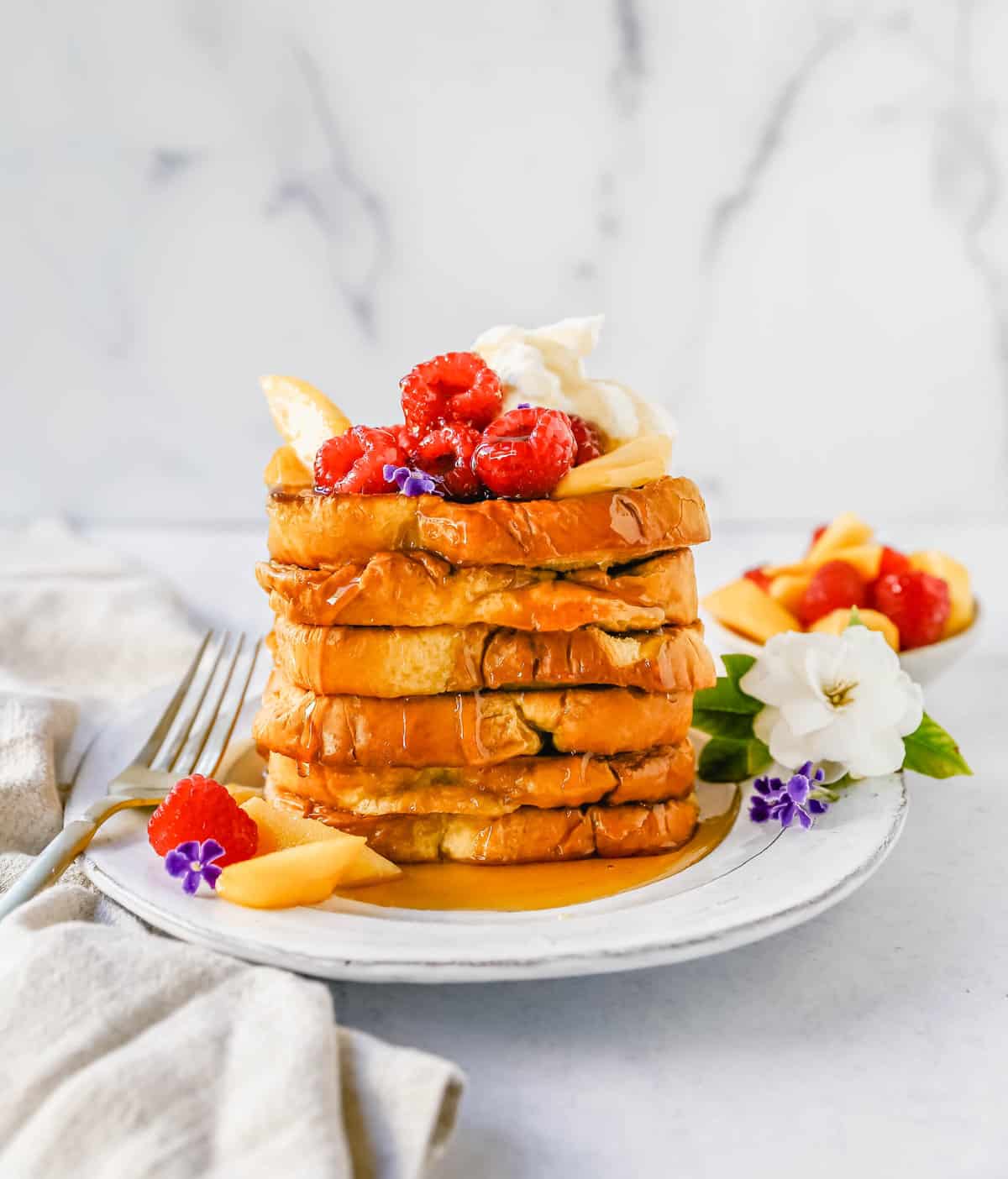 Easy Sheet Pan French Toast is made by dipping the bread into a custard batter and baking on a sheet pan in the oven. It makes it so much easier to make homemade french toast! Top this Oven Baked French Toast with a sweet Mascarpone Cream and Sweetened Fresh Fruit.