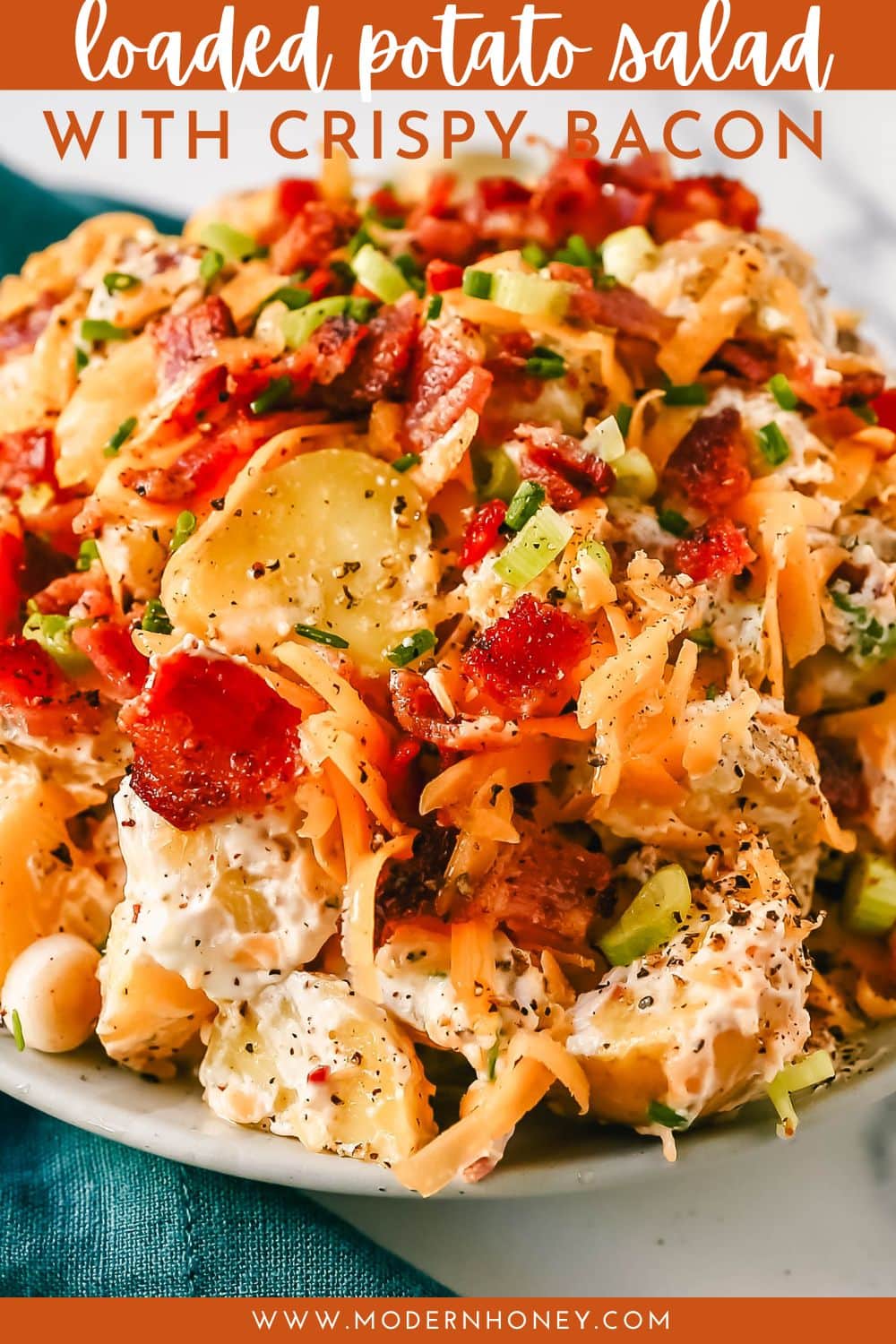 The Best Loaded Potato Salad Recipe is made with creamy gold potatoes, crispy bacon, cheddar cheese, green onions, sour cream, mayonnaise, seasoned salt, and pepper. The perfect baked potato salad recipe is perfect for your next party, potluck, or as a BBQ side dish.