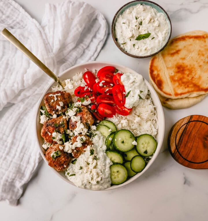 Greek Chicken Meatballs are moist and flavorful without any fillers...just spices and herbs. These Greek Turkey Meatballs are served with homemade tzatziki sauce, fresh cucumbers, tomatoes, and rice. 