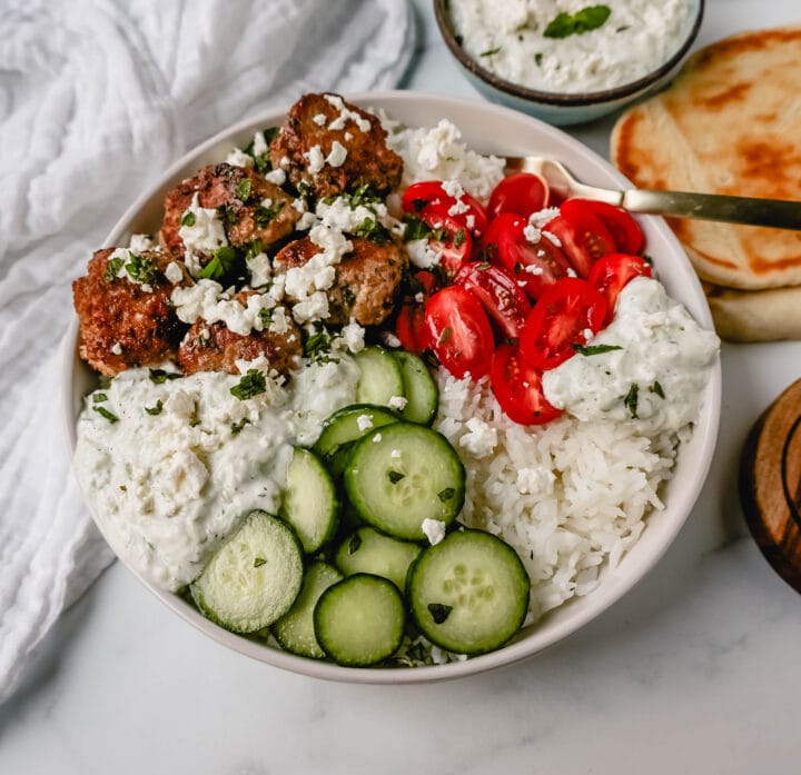 Greek Chicken Meatballs are moist and flavorful without any fillers...just spices and herbs. These Greek Turkey Meatballs are served with homemade tzatziki sauce, fresh cucumbers, tomatoes, and rice. 