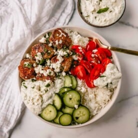 Greek Chicken Meatballs are moist and flavorful without any fillers...just spices and herbs. These Greek Turkey Meatballs are served with homemade tzatziki sauce, fresh cucumbers, tomatoes, and rice.