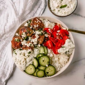 Greek Chicken Meatballs are moist and flavorful without any fillers...just spices and herbs. These Greek Turkey Meatballs are served with homemade tzatziki sauce, fresh cucumbers, tomatoes, and rice. 