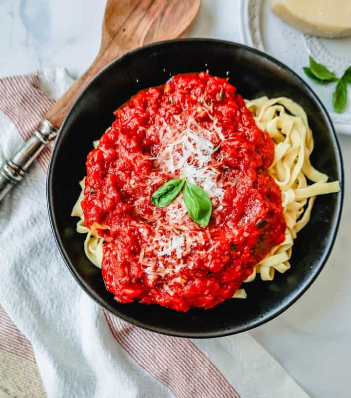 Pasta with homemade marinara sauce. This Marinara Sauce is the best tomato sauce recipe! This San Marzano Tomato Sauce is made with extra-virgin olive oil, garlic, San Marzano canned tomatoes, tomato paste, fresh herbs, and spices. This homemade marinara sauce simmers for hours to create the most robust and flavorful easy marinara sauce.