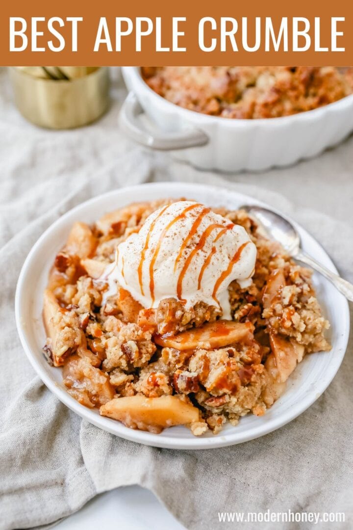Homemade Apple Crumble Recipe made with fresh apples tossed in cinnamon sugar and topped with a brown sugar crumble made with butter, pecans, brown sugar, and flour. This apple crumble is baked until bubbly and topped with vanilla ice cream. An easy apple dessert!