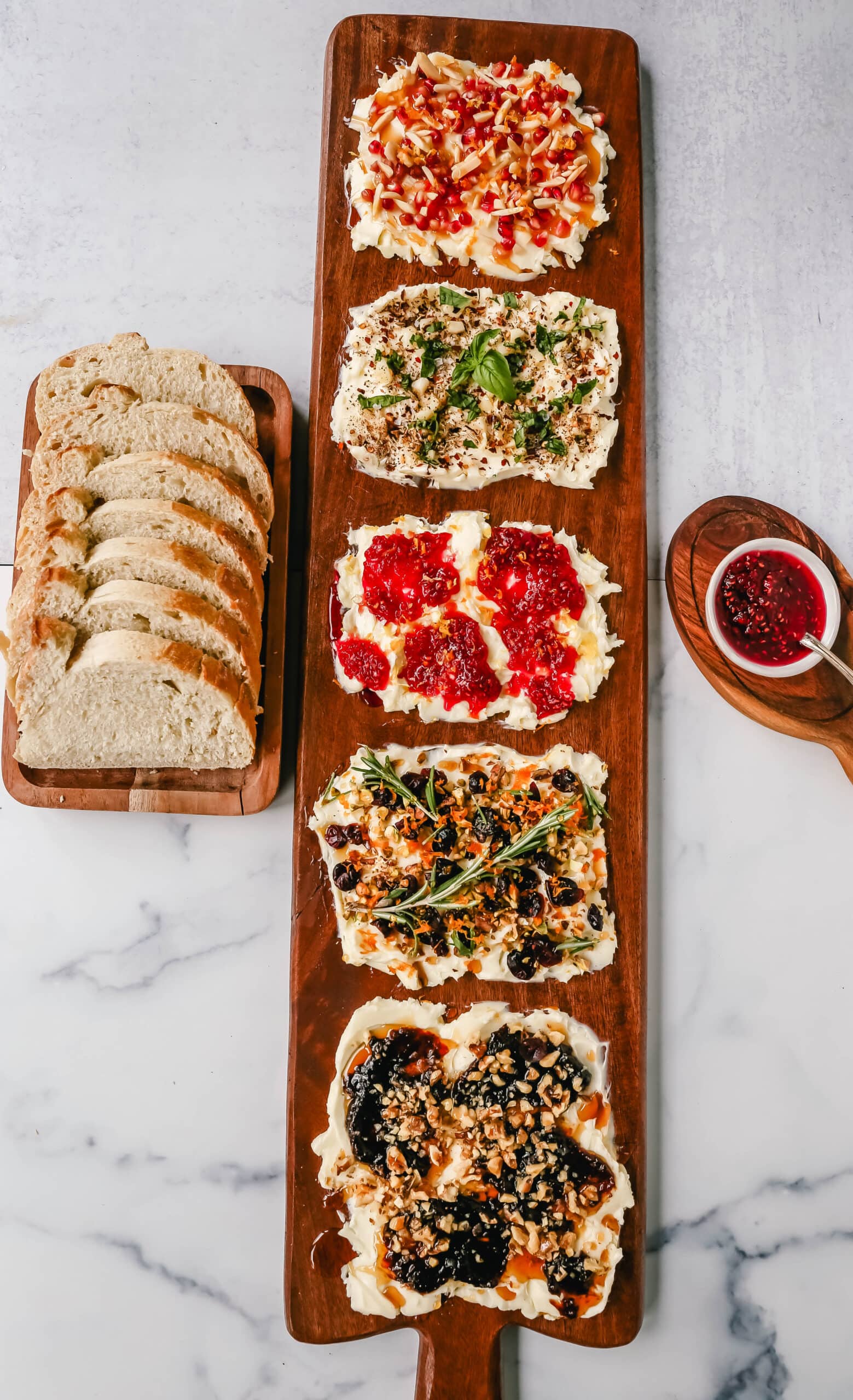 A Butter Board with fresh butter is spread onto a board and topped with an assortment of toppings and served with warm bread. This Butter Board with Toppings is such a fun appetizer for a party! A Butter Board is made by spreading salted, slightly softened butter onto a board and topping it with your favorite toppings like jam and fresh lemon zest and hot honey, walnuts, and fig jam. A savory butter board can be made with butter, roasted garlic, fresh basil, italian seasoning, and red chili flakes. Warm French bread slices are dipped into each savory or sweet butter combination. This Butter Board became famous on TikTok and is now a popular appetizer at parties.