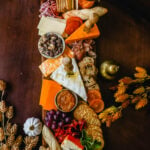 Festive Charcuterie Board perfect to celebrate Thanksgiving or Friendsgiving with friends and family. How to pick out the perfect meats, cheeses, fruits, jams, crackers, and dips for your Fall charcuterie spread. Tips and tricks for making the best charcuterie board.