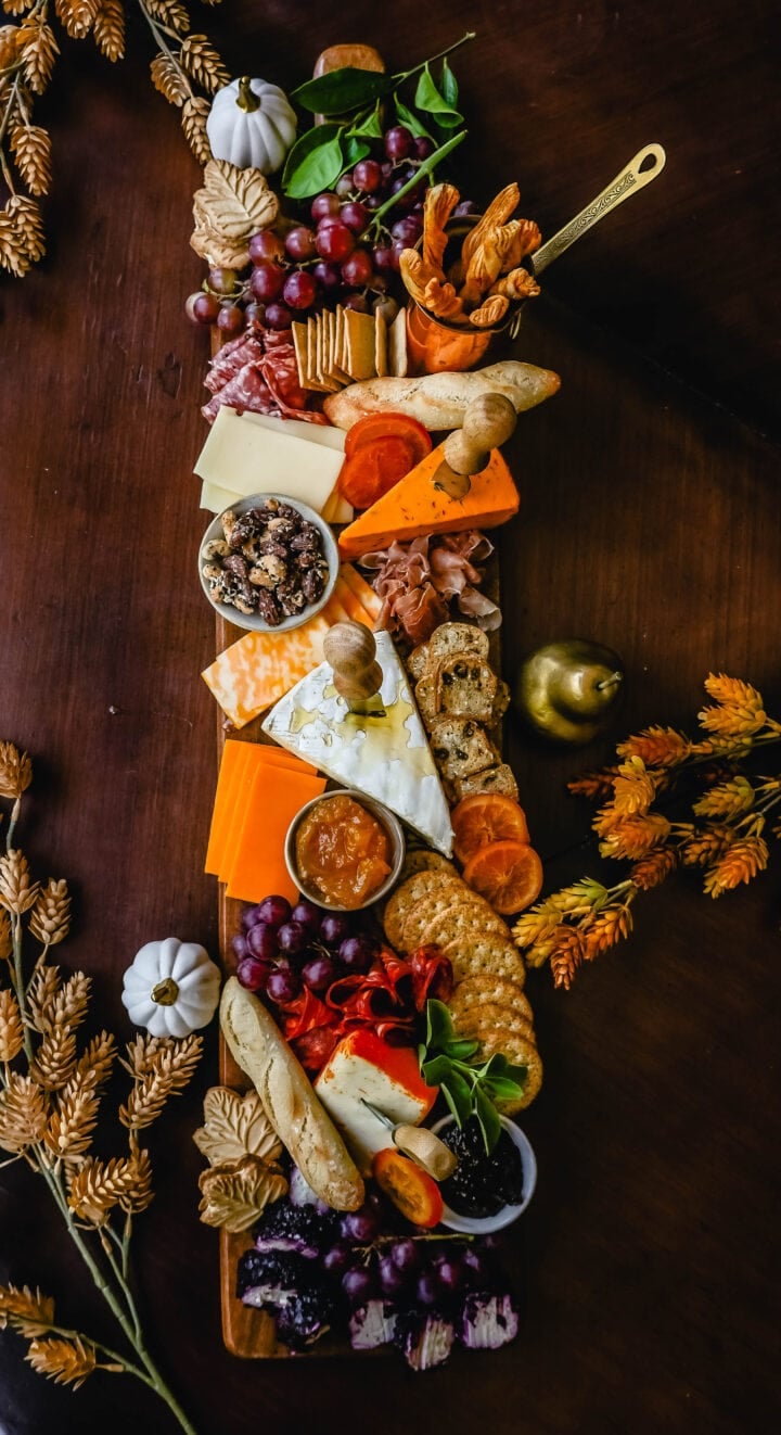 Festive Charcuterie Board perfect to celebrate Thanksgiving or Friendsgiving with friends and family. How to pick out the perfect meats, cheeses, fruits, jams, crackers, and dips for your Fall charcuterie spread. Tips and tricks for making the best charcuterie board.