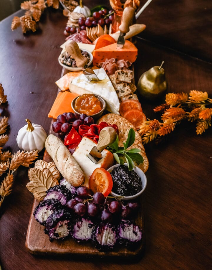 Festive Charcuterie Board perfect to celebrate Thanksgiving or Friendsgiving with friends and family. How to pick out the perfect meats, cheeses, fruits, jams, crackers, and dips for your Fall charcuterie spread. Tips and tricks for making the best charcuterie board.