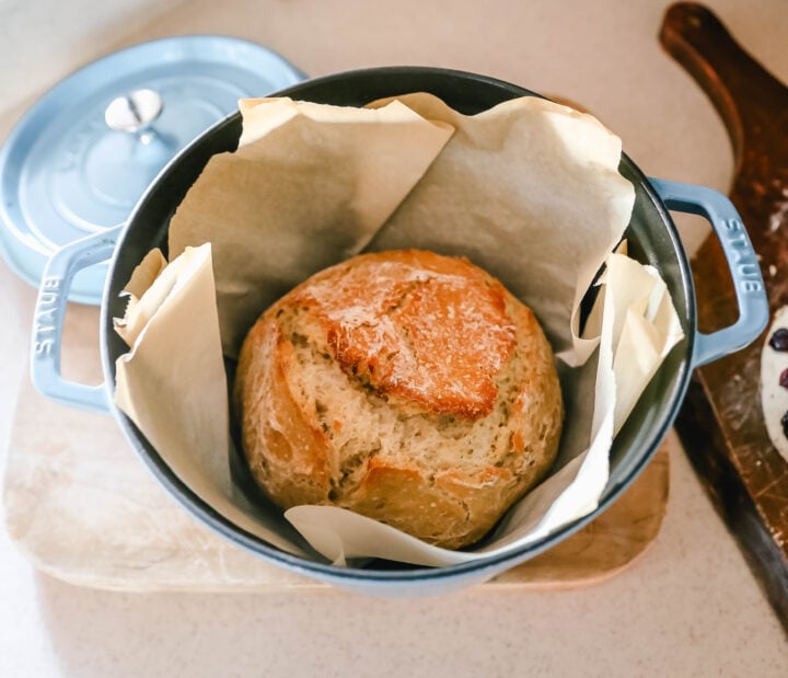 Making homemade artisan bread at cabin. This No Knead Bread is baked in a dutch oven and is the perfect crusty french bread recipe. This makes a beautiful artisan loaf of bread and is so easy! The only ingredients you need are flour, water, salt, and yeast for the perfect overnight bread.
