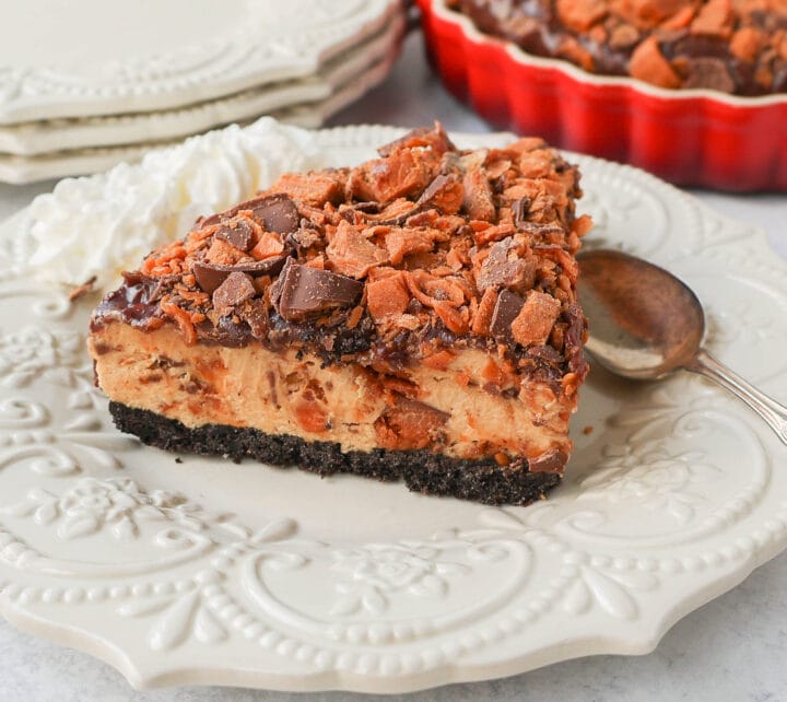 No-Bake Chocolate Peanut Butter Butterfinger Pie with a chocolate OREO crust, creamy peanut butter filling with Butterfinger candy bars, chocolate ganache, and topped with fresh whipped cream and Butterfinger. The best creamy Butterfinger pie recipe!