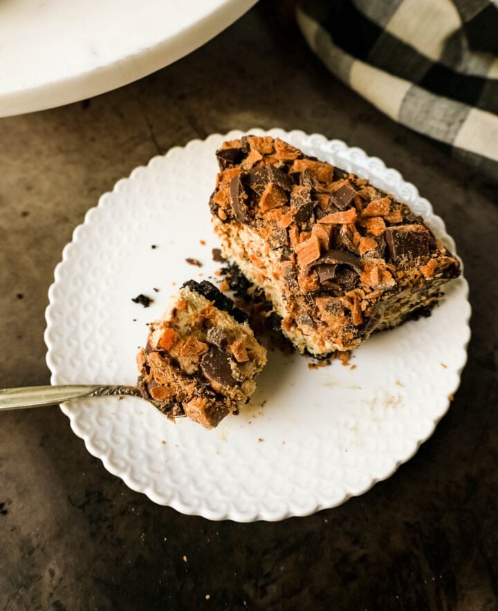 No-Bake Chocolate Peanut Butter Butterfinger Pie with a chocolate OREO crust, creamy peanut butter filling with Butterfinger candy bars, chocolate ganache, and topped with fresh whipped cream and Butterfinger. The best creamy Butterfinger pie recipe!