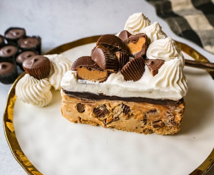 No-Bake Chocolate Peanut Butter Pie with a graham cracker crust, creamy peanut butter filling with peanut butter cups, chocolate ganache, and topped with fresh whipped cream and peanut butter cups. The best chocolate peanut butter pie recipe!