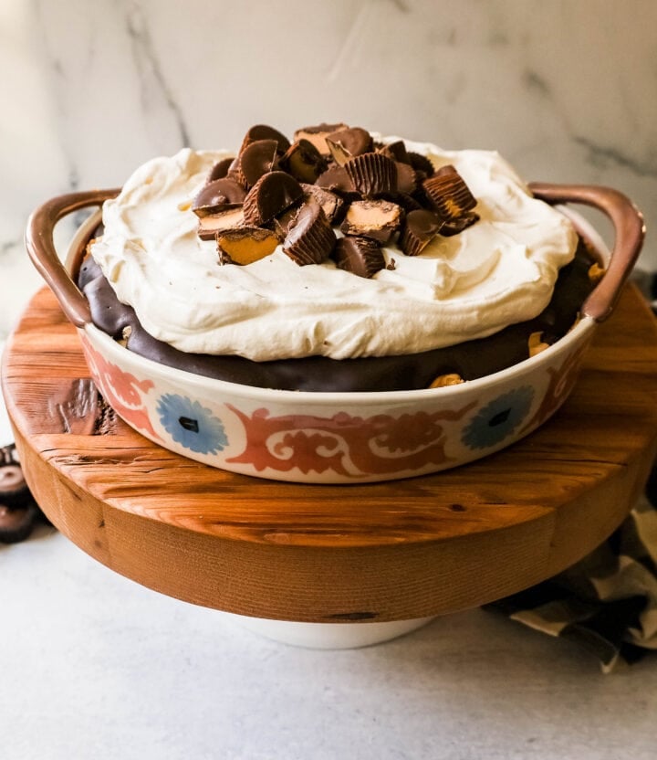 No-Bake Chocolate Peanut Butter Pie with a graham cracker crust, creamy peanut butter filling with peanut butter cups, chocolate ganache, and topped with fresh whipped cream and peanut butter cups. The best chocolate peanut butter pie recipe!