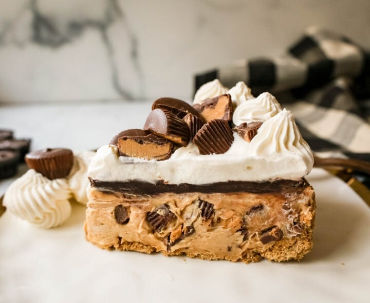 No-Bake Chocolate Peanut Butter Pie with a graham cracker crust, creamy peanut butter filling with peanut butter cups, chocolate ganache, and topped with fresh whipped cream and peanut butter cups. The best chocolate peanut butter pie recipe!