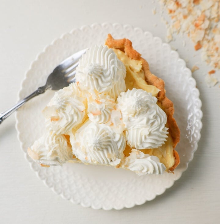 Easy Homemade Coconut Cream Pie made with pudding mix, sweetened condensed milk, whole milk, whipped cream, and sweetened shredded coconut all in a buttery pie crust and topped with sweet whipped cream. This is the best coconut cream pie recipe!