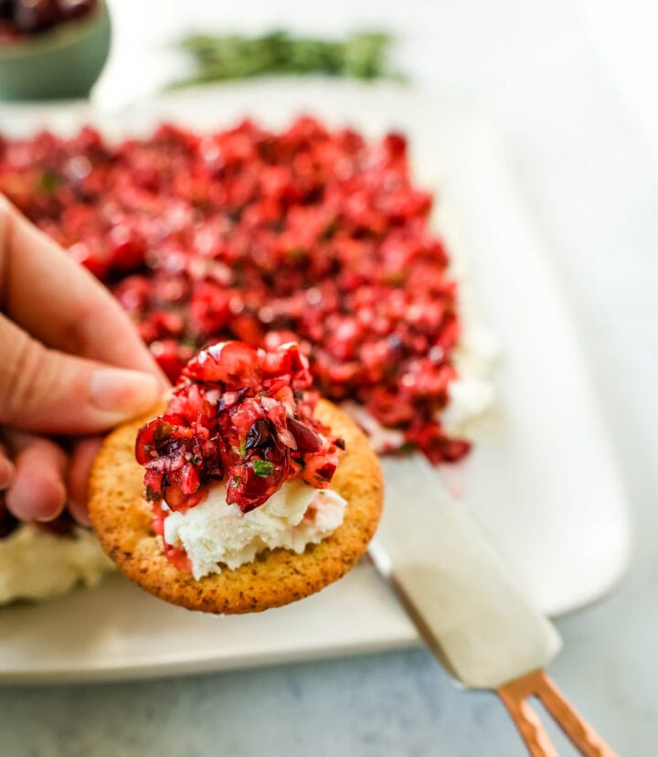 This Cranberry Jalapeno Cream Cheese Dip is a festive appetizer that is creamy, tart, a tad spicy, and sweet. This Cranberry Jalapeno Dip is made with fresh cranberry salsa atop cream cheese. It is the perfect holiday party appetizer!