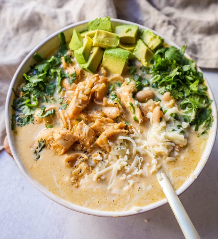 The Best White Chicken Chili Recipe made with shredded chicken, jalapeno, onion, spices, in a creamy chicken broth with salsa verde, cream cheese, white beans, shredded cheese, and fresh cilantro. The perfect creamy white chicken chili recipe!