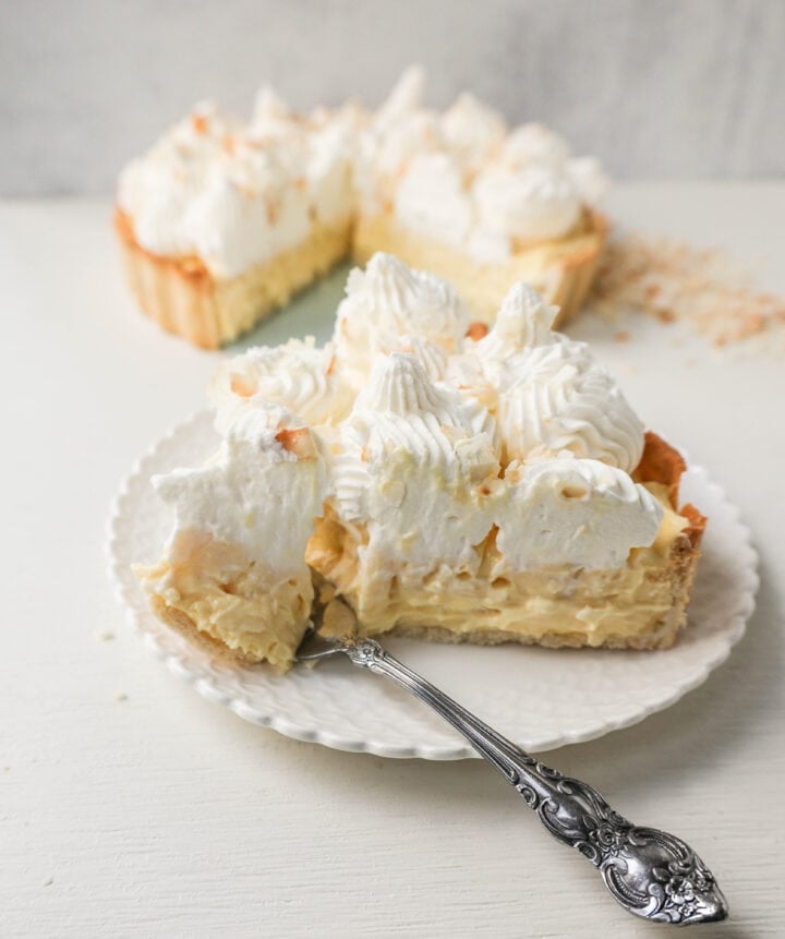 Easy Homemade Coconut Cream Pie made with pudding mix, sweetened condensed milk, whole milk, whipped cream, and sweetened shredded coconut all in a buttery pie crust and topped with sweet whipped cream. This is the best coconut cream pie recipe!