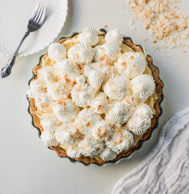 Easy Homemade Coconut Cream Pie made with pudding mix, sweetened condensed milk, whole milk, whipped cream, and sweetened shredded coconut all in a buttery pie crust and topped with sweet whipped cream. This is the best coconut cream pie recipe!