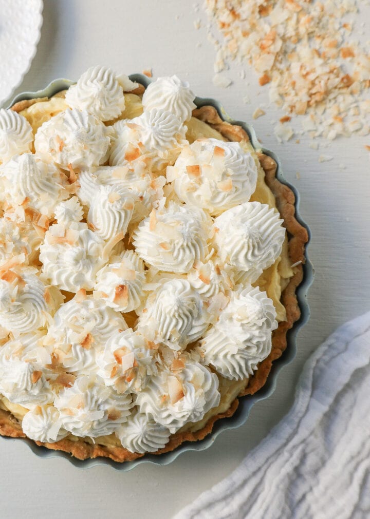 Easy Homemade Coconut Cream Pie made with pudding mix, sweetened condensed milk, whole milk, whipped cream, and sweetened shredded coconut all in a buttery pie crust and topped with sweet whipped cream. This is the best coconut cream pie recipe!