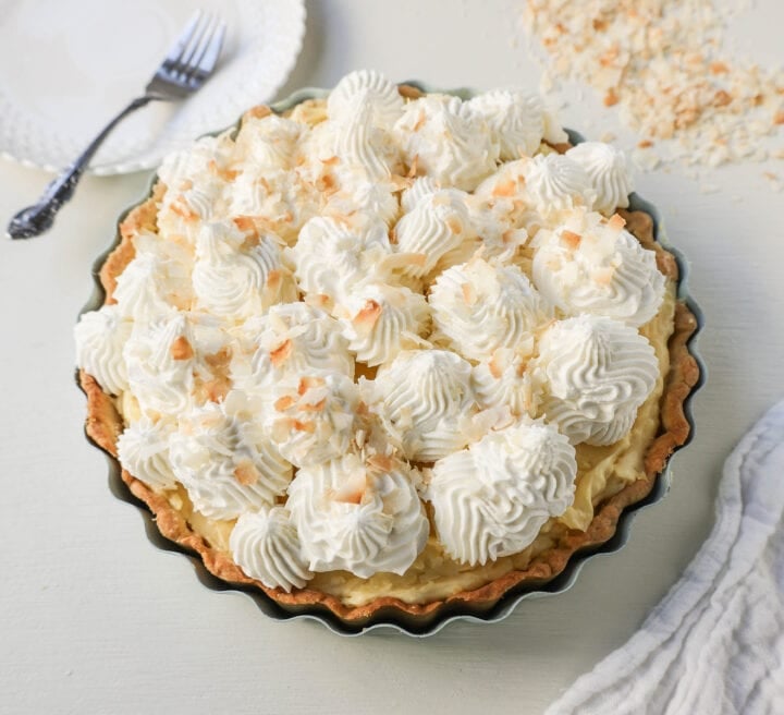 Easy Homemade Coconut Cream Pie made with pudding mix, sweetened condensed milk, whole milk, whipped cream, and sweetened shredded coconut all in a buttery pie crust and topped with sweet whipped cream. This is the best coconut cream pie recipe!