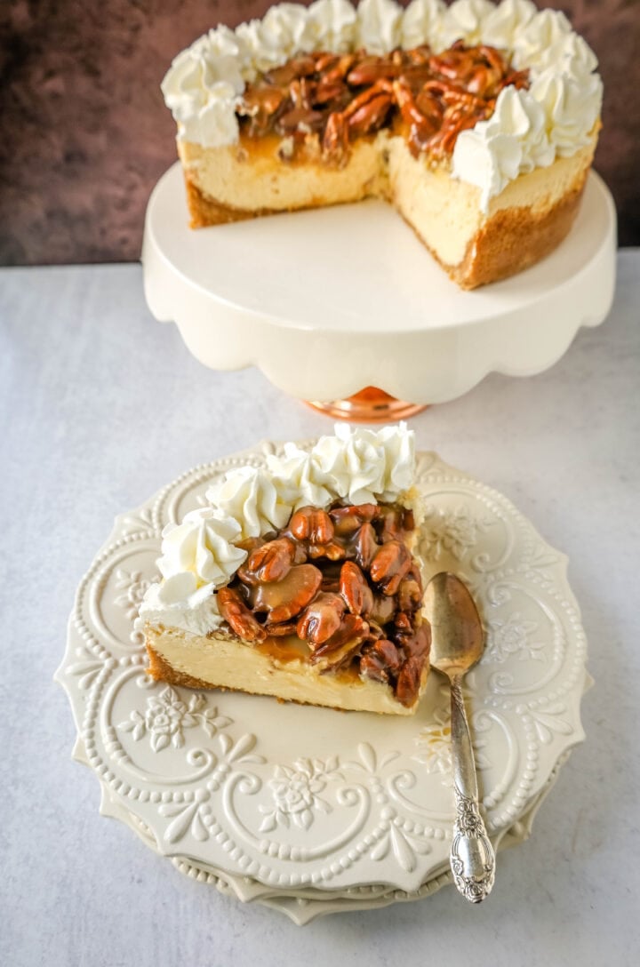 This Pecan Cheesecake is a rich, creamy homemade cheesecake topped with decadent brown sugar pecan praline sauce. This Pecan Praline Cheesecake combines pecan pie and cheesecake into one perfect pecan dessert!