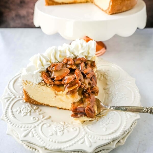 This Pecan Cheesecake is a rich, creamy homemade cheesecake topped with decadent brown sugar pecan praline sauce. This Pecan Praline Cheesecake combines pecan pie and cheesecake into one perfect pecan dessert!