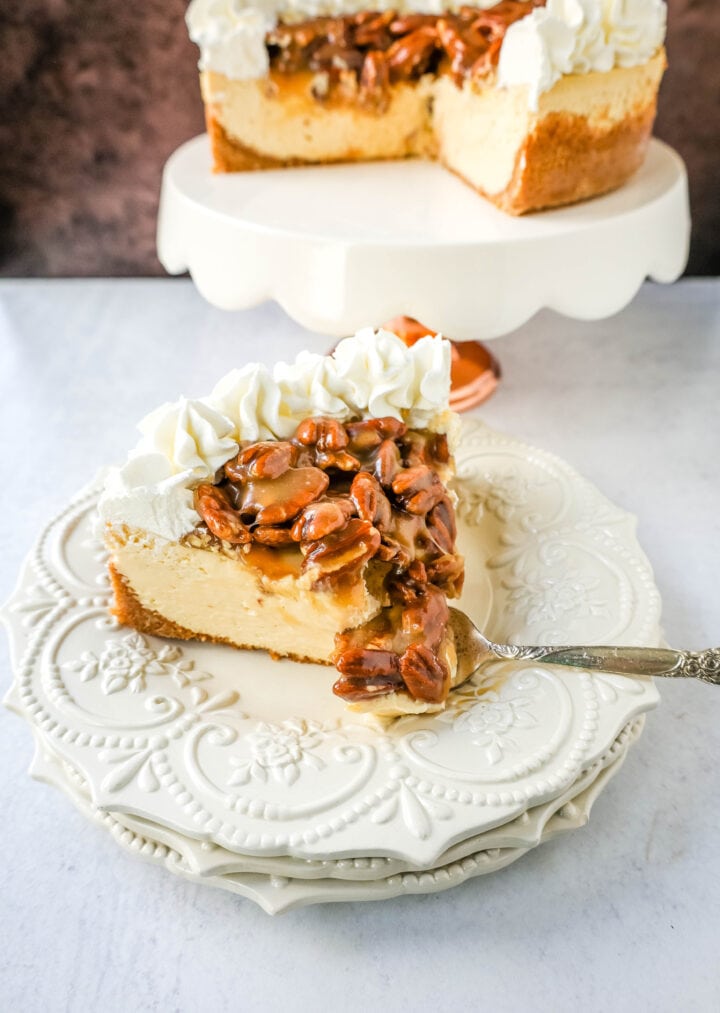 This Pecan Cheesecake is a rich, creamy homemade cheesecake topped with decadent brown sugar pecan praline sauce. This Pecan Praline Cheesecake combines pecan pie and cheesecake into one perfect pecan dessert!