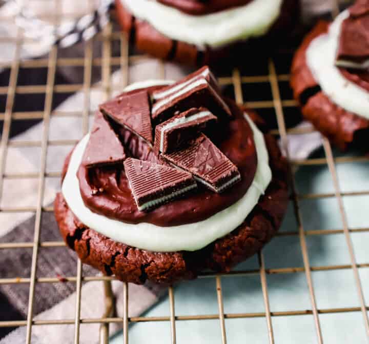 Frosted Mint Chocolate Brownie Cookies are made with a chewy double chocolate cookie, topped with creamy mint frosting, chocolate ganache, and Andes mints. These Andes Mint Cookies are the perfect holiday mint chocolate cookie recipe!