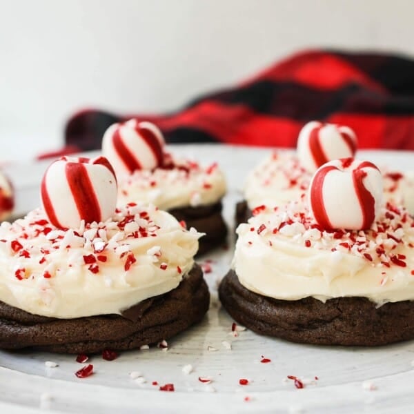 Soft, decadent chocolate cookies topped with homemade creamy peppermint frosting and crushed candy canes. The perfect peppermint frosted chocolate cookie recipe! A delicious peppermint and chocolate Christmas cookie.