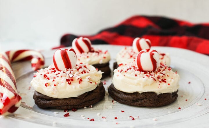 Soft, decadent chocolate cookies topped with homemade creamy peppermint frosting and crushed candy canes. The perfect peppermint frosted chocolate cookie recipe! A delicious peppermint and chocolate Christmas cookie.