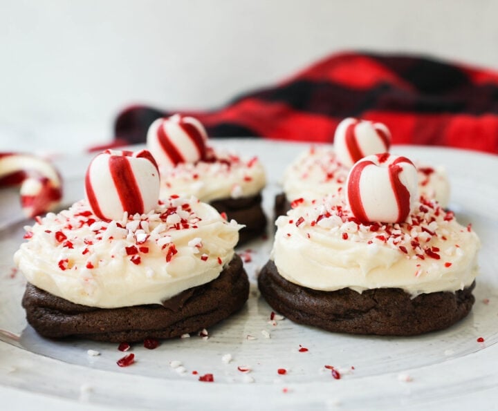 Soft, decadent chocolate cookies topped with homemade creamy peppermint frosting and crushed candy canes. The perfect peppermint frosted chocolate cookie recipe! A delicious peppermint and chocolate Christmas cookie.