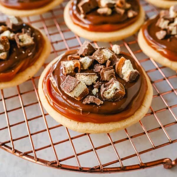 Twix Cookies made with soft sugar shortbread topped with rich caramel and milk chocolate and sprinkled with chopped Twix candy bars. These Millionaire Cookies are the best chocolate caramel shortbread cookie!